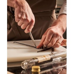 personne ouvrant des gousses de vanille Bourbon Madagascar sur une planche