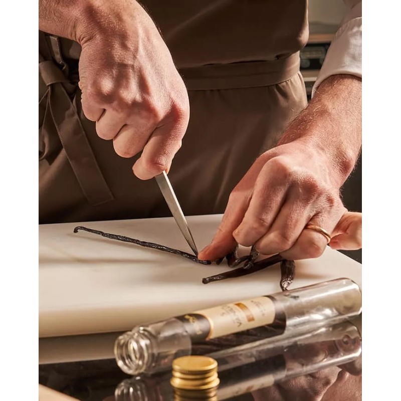 personne ouvrant des gousses de vanille Bourbon Madagascar sur une planche