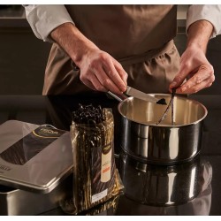 personne grattant les graines d’une gousse de vanille Bourbon Madagascar