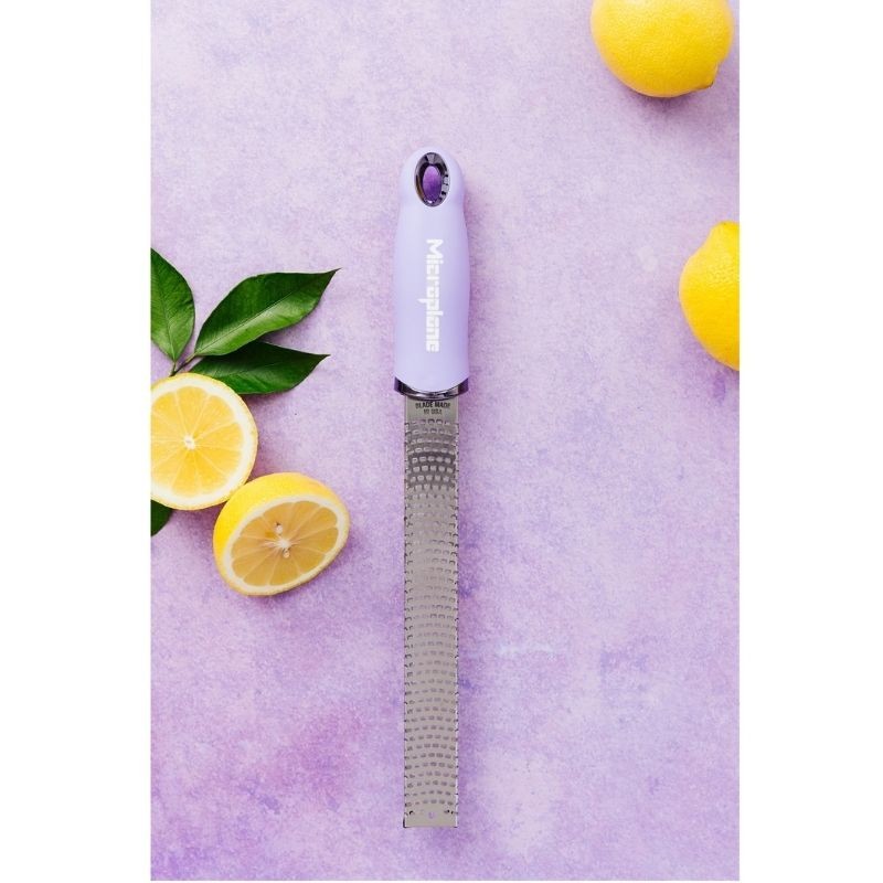 zesteur râpe premium fleur de lavande posé sur fond violet avec citrons et feuilles pour zestes ultra précis