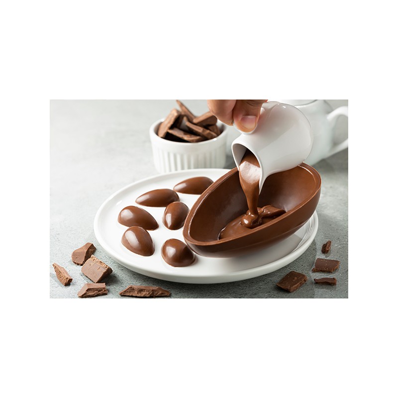 chocolat au lait 35% de cacao versé dans un moule pour confection d’œufs et pralines, utilisé pour pâtisserie gourmande.