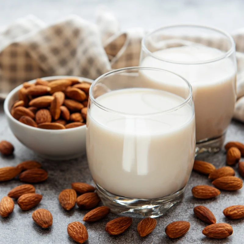 Verres de lait d’amande maison avec amandes entières, boisson végétale sans lactose naturelle