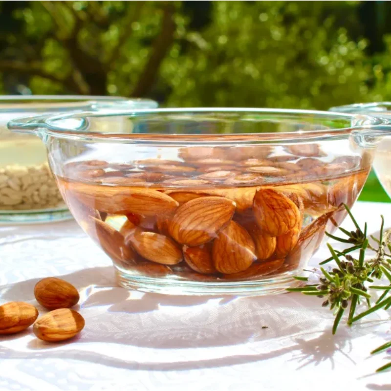 Trempage d’amandes entières dans un saladier en verre, préparation naturelle pour recette crue ou activation des fruits secs