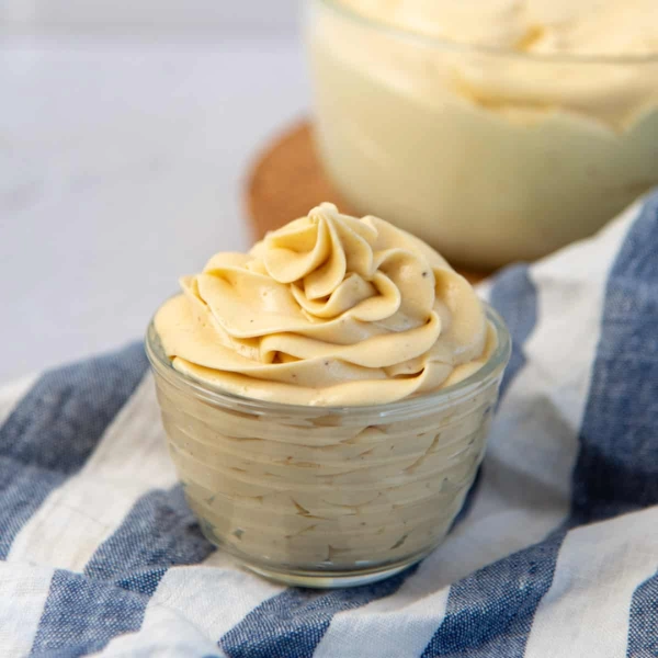 Crème mousseline à la vanille dressée à la douille dans un petit bol en verre