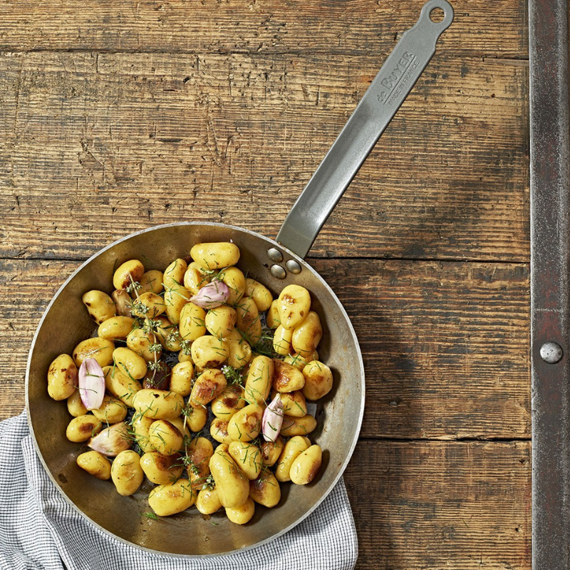 Poêle De Buyer en acier inoxydable avec pommes de terre rissolées et herbes