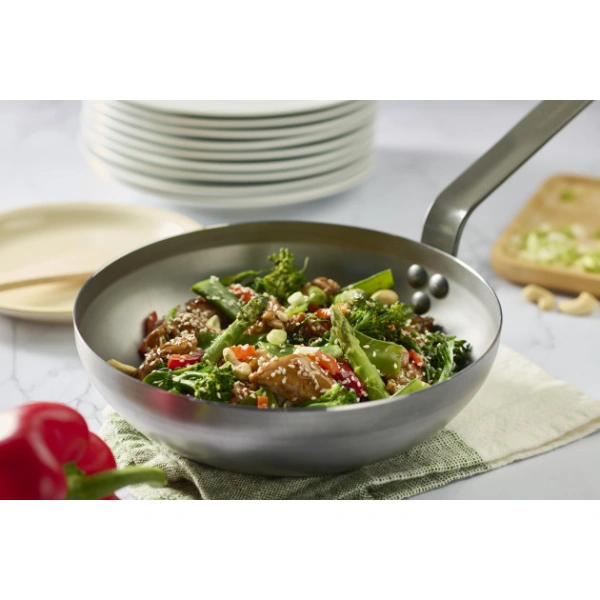 Wok en acier De Buyer Loqy avec légumes sautés et graines de sésame