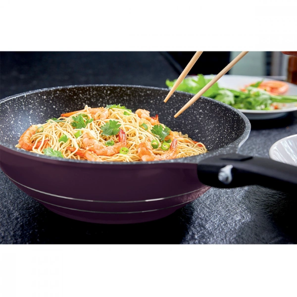 Wok en fonte d’aluminium avec revêtement antiadhésif contenant des nouilles sautées aux crevettes et légumes