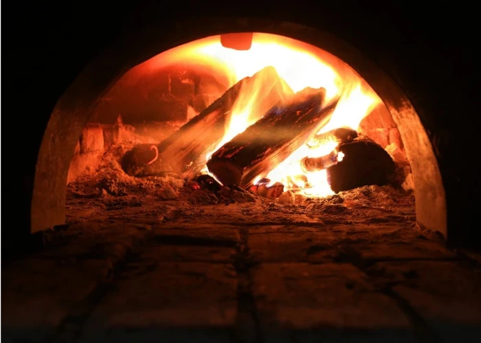 Feu de bois intense à l'intérieur d'un four traditionnel en briques pour une cuisson authentique