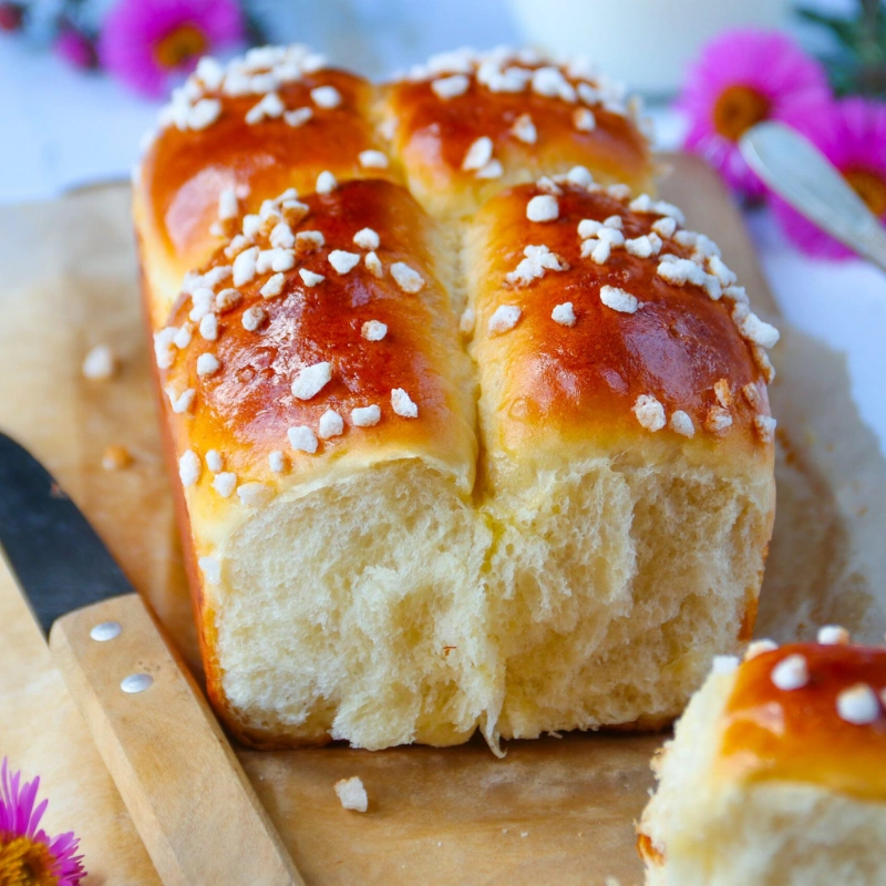 Brioche moelleuse dorée au four, décorée de perles de sucre