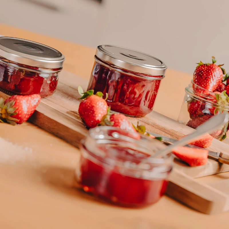 Pots de confiture de fraise maison sur planche en bois avec fraises fraîches