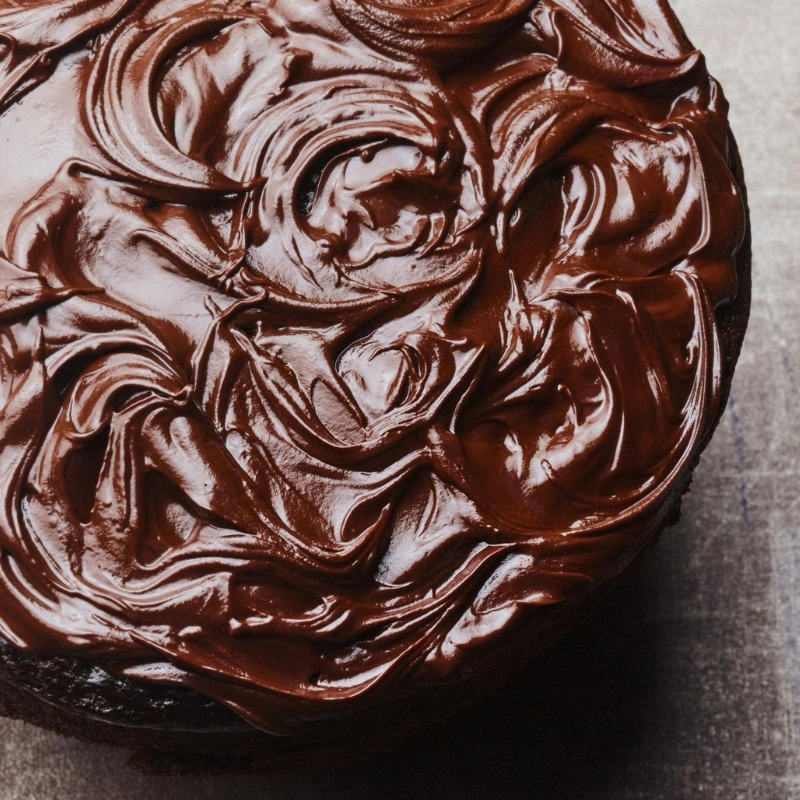 Nappage chocolat souple et brillant appliqué à la spatule sur gâteau