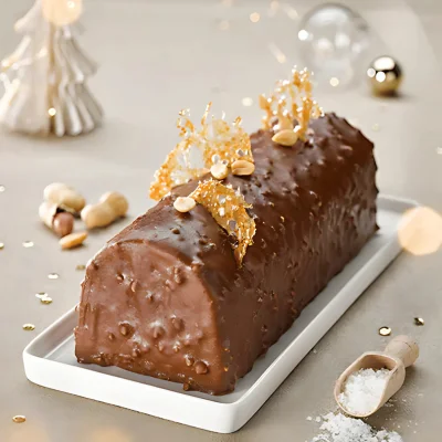 Bûche de Noël au chocolat et cacahuète, recette avec pâte de cacahuète d'Argentine Sébalcé décorée de caramel et fruits secs